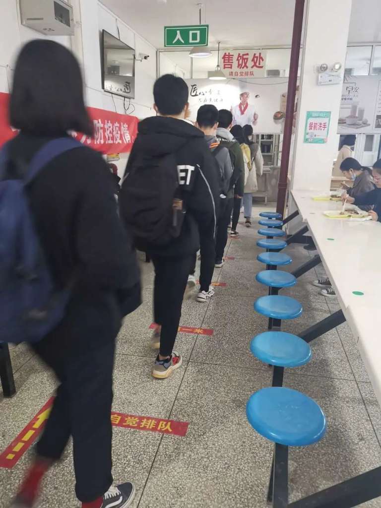 学生戴口罩间隔一米排队